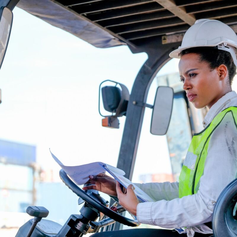 African technician worker woman stay on tractor and look to some directions