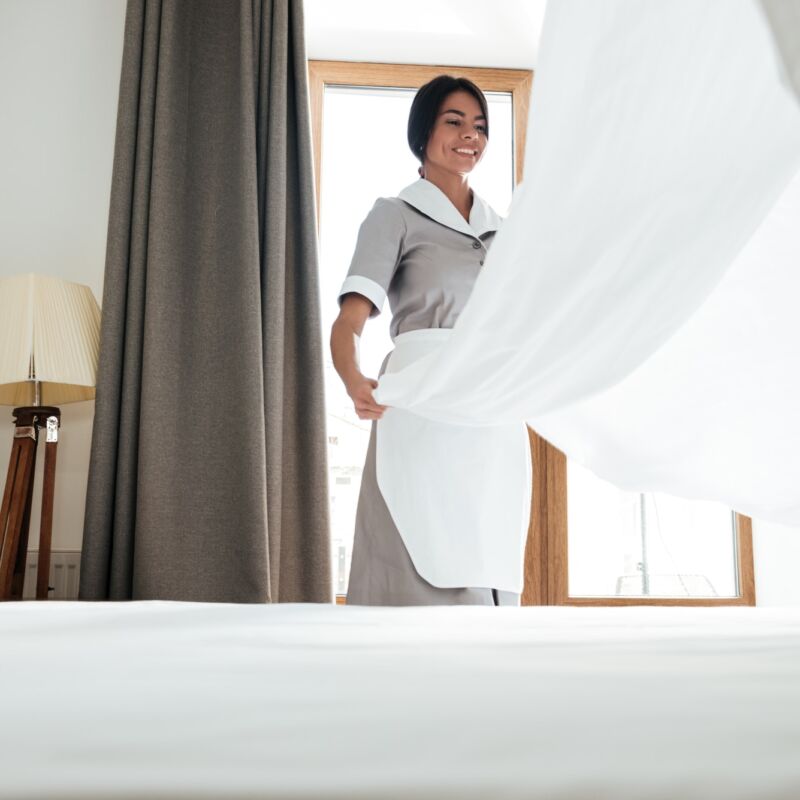 Hotel maid changing bed sheet