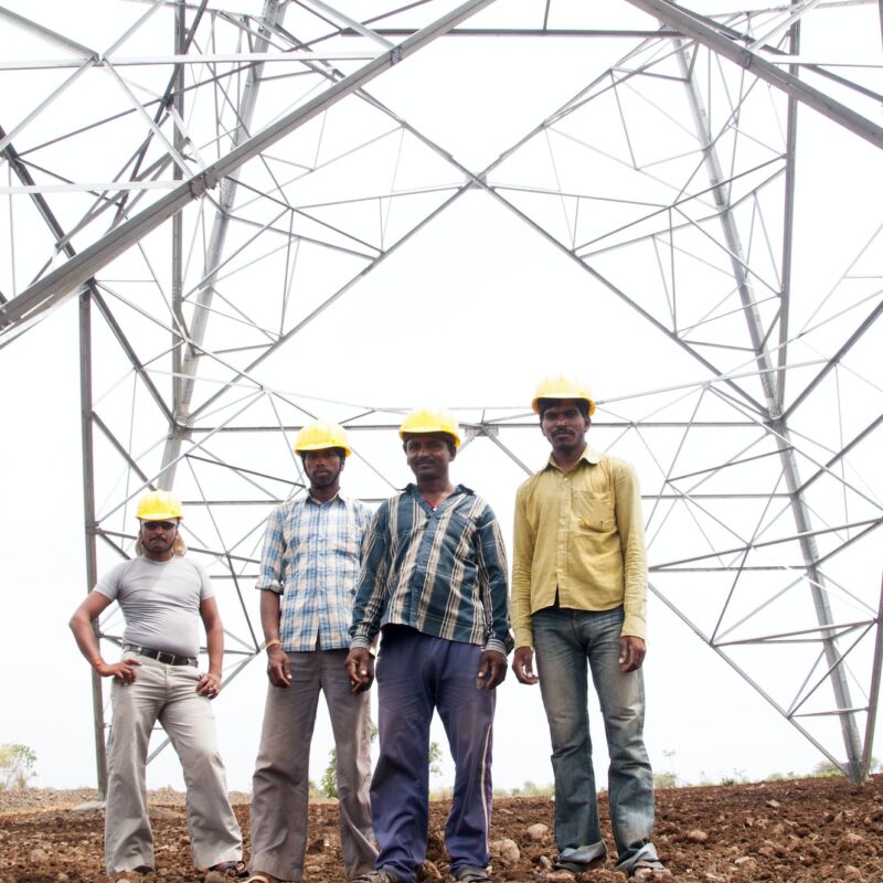 Portrait of Pylon construction workers, India.